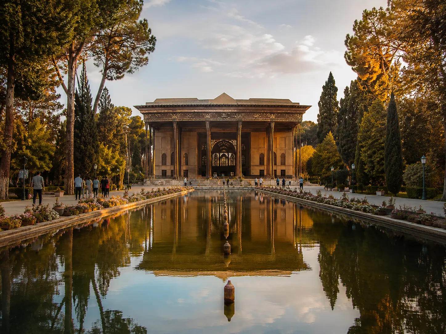 Chehel Sotoun palace reflected in water pool surrounded by Persian garden in Isfahan