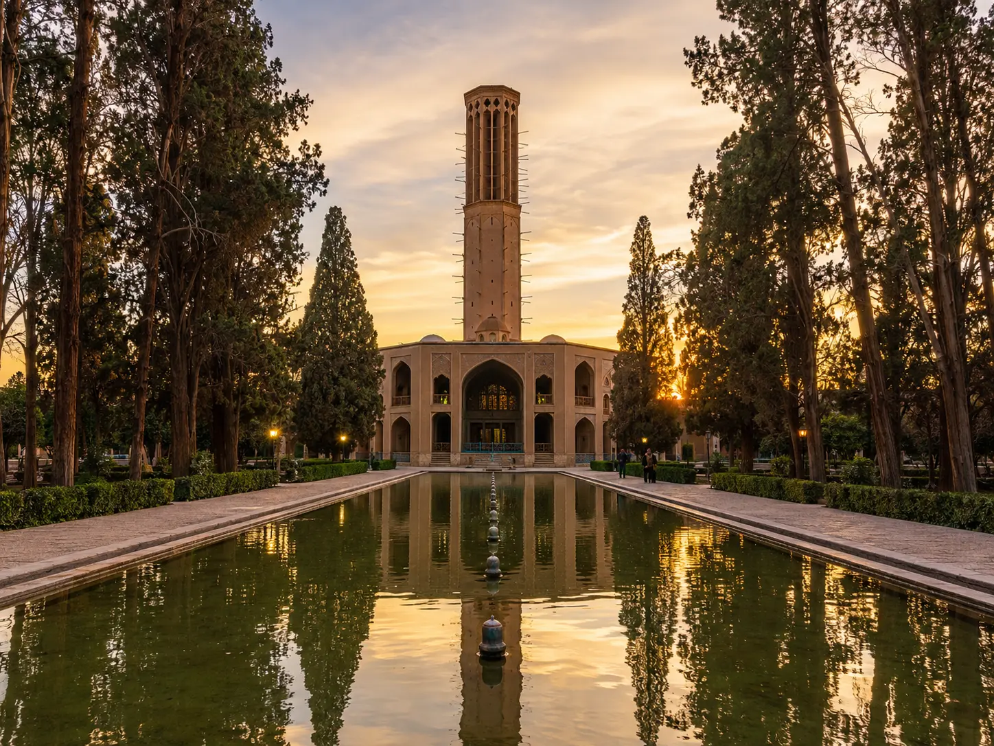Dowlat Abad Garden in Yazd with historic windcatcher, reflecting pool, and sunset light